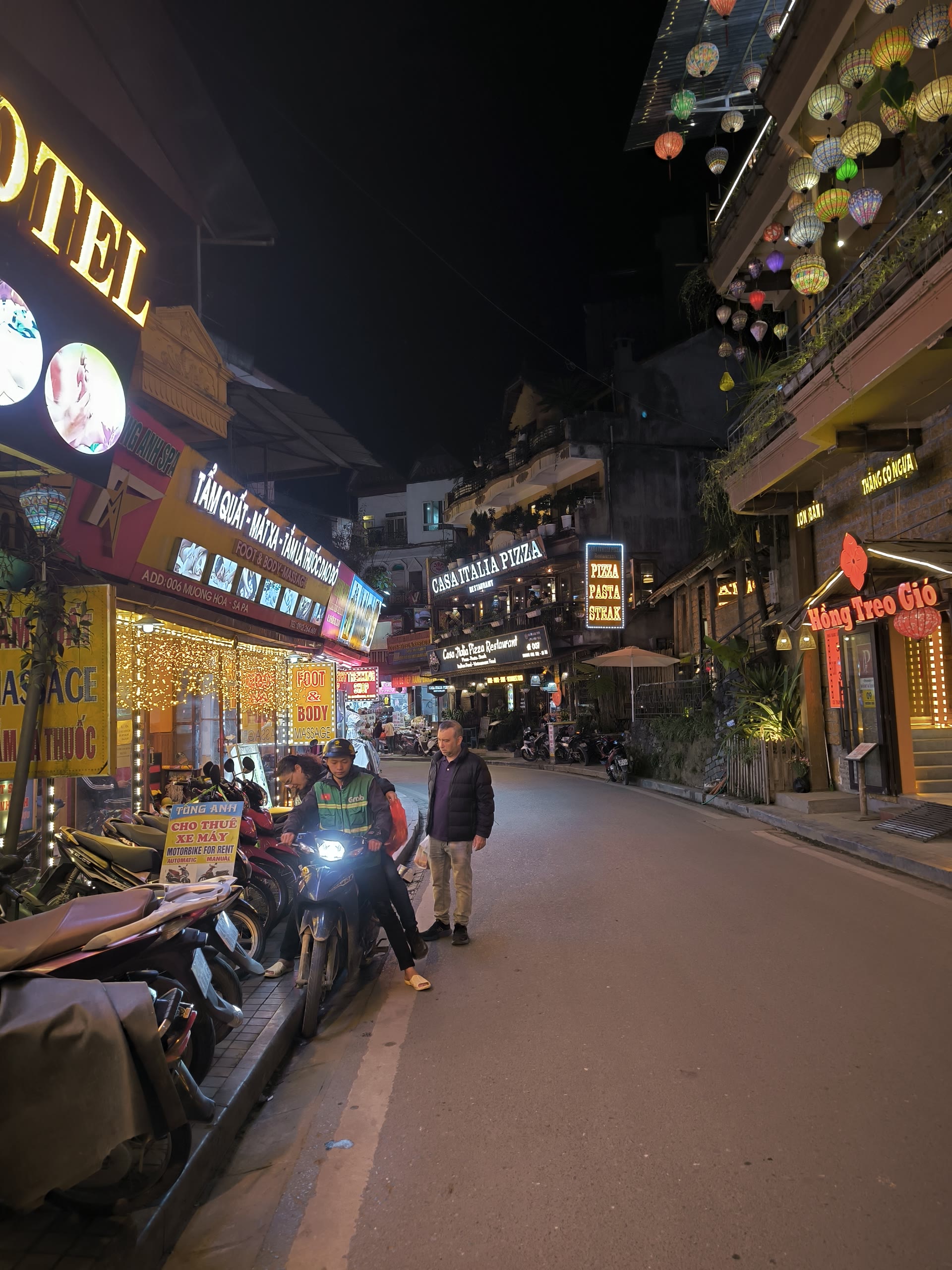 ถนนกลางเมืองซาปายามค่ำคืนที่เต็มไปด้วยร้านอาหารและแสงไฟ
